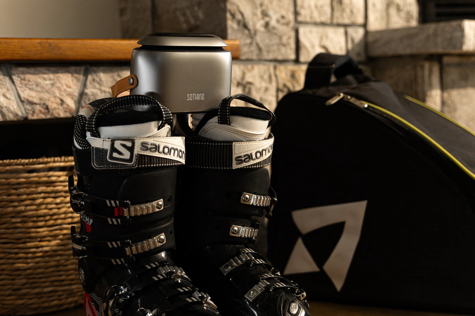 Originales SOTHING-Ultra-Grey-Foto mit schwarzen Salomon-Skischuhen an einer Steinwand