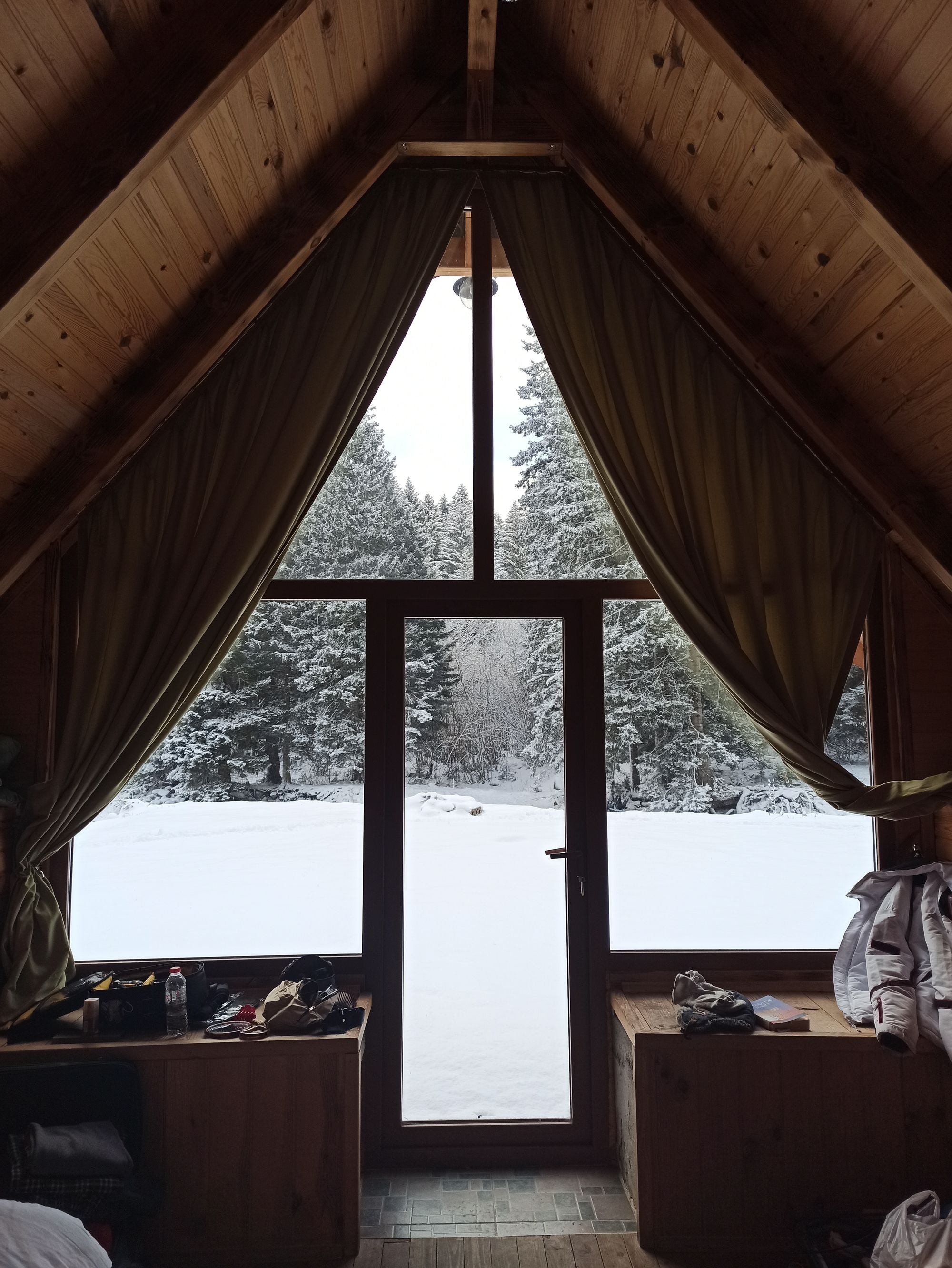 Ruhige Skihütte aus Holz mit Blick auf einen verschneiten Wald